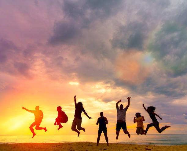 people happy jumping in the air at sunset