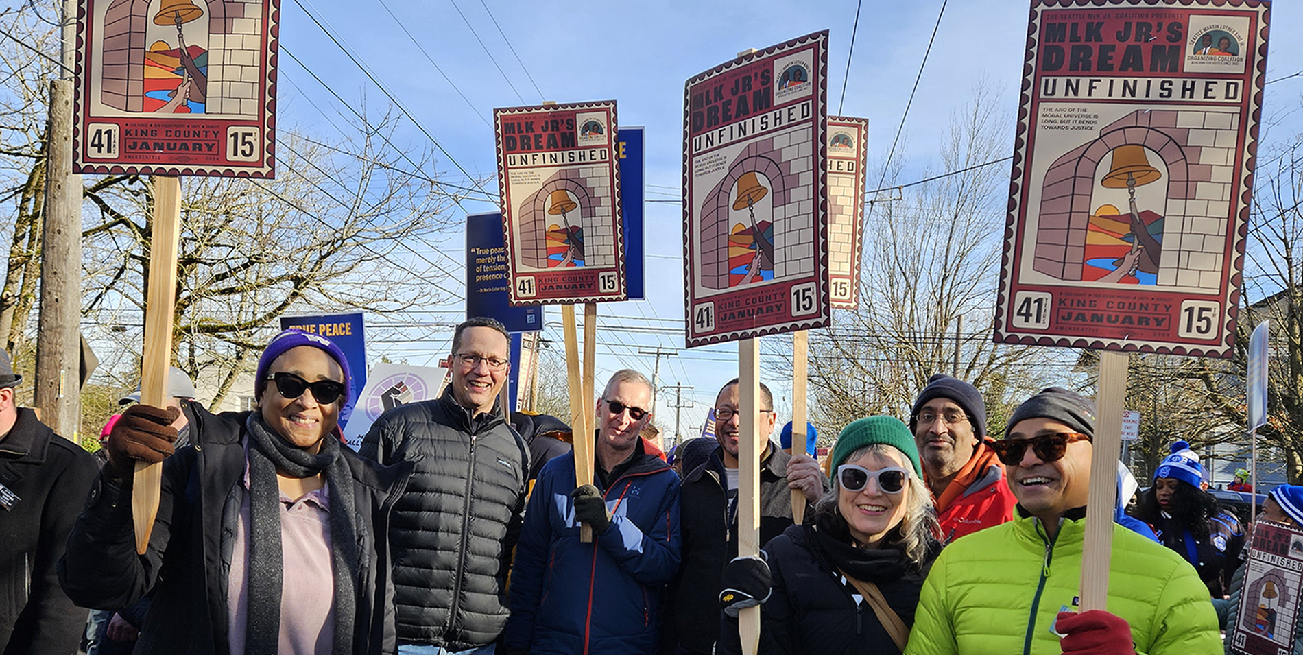 Department employees participating in the 2024 MLK March, holding signs